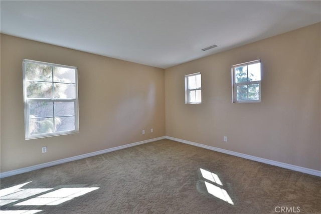 carpeted spare room with baseboards and visible vents