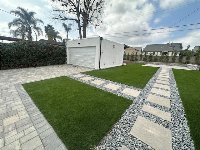 view of yard with a detached garage, an outdoor structure, and fence