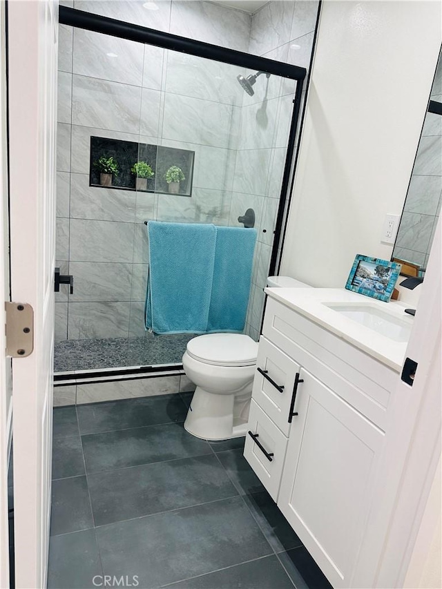 full bathroom with vanity, tile patterned floors, toilet, and a stall shower