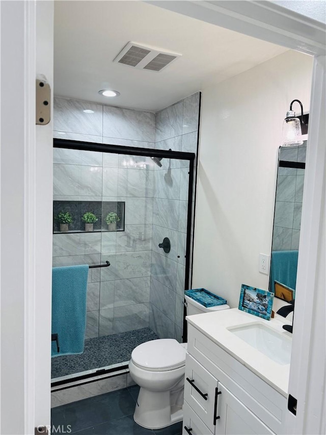 full bathroom featuring visible vents, a shower stall, vanity, and toilet