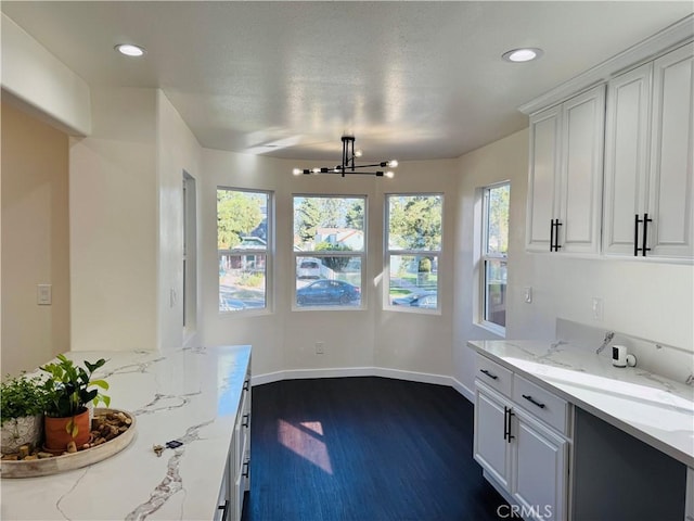 kitchen featuring white cabinetry, recessed lighting, light stone countertops, and dark wood-style flooring