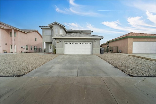 view of front facade featuring concrete driveway, roof mounted solar panels, fence, and stucco siding