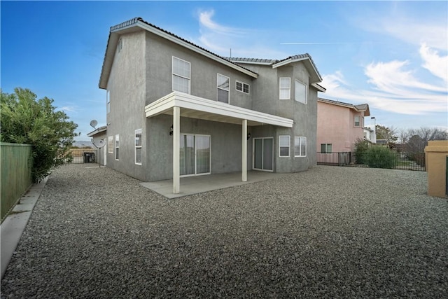 back of property with a patio, a tile roof, a fenced backyard, and stucco siding