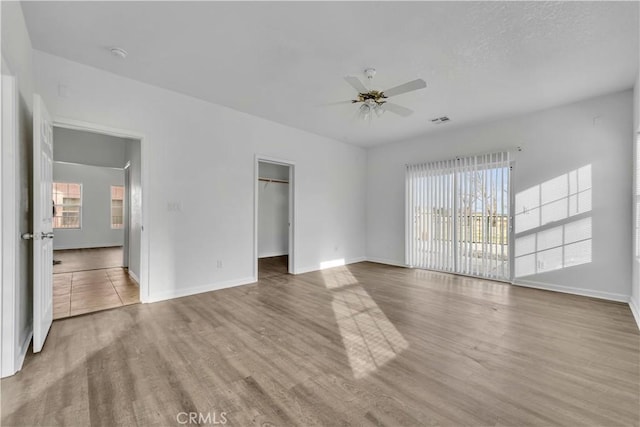 interior space featuring a ceiling fan, baseboards, and wood finished floors