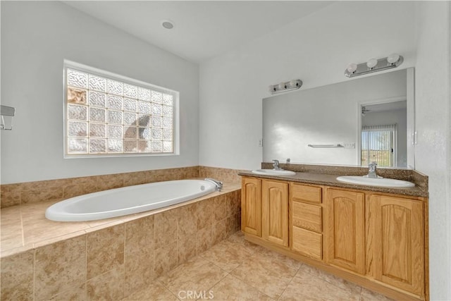 full bathroom featuring tile patterned floors, double vanity, a sink, and a bath