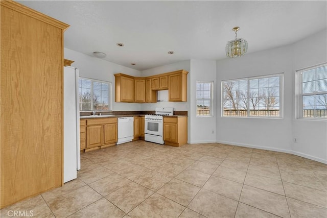 kitchen with a chandelier, white appliances, a sink, and baseboards