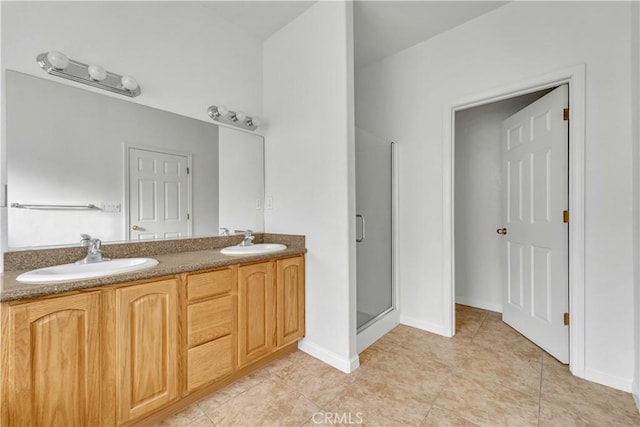 bathroom featuring a stall shower, tile patterned floors, a sink, and double vanity