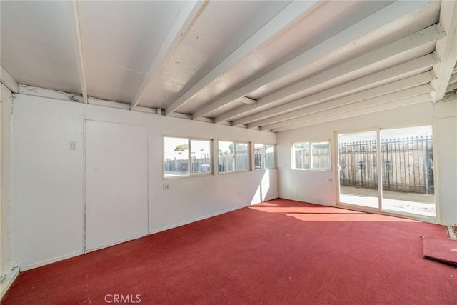 carpeted spare room featuring beamed ceiling