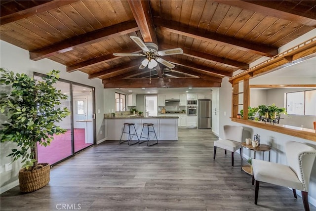 interior space featuring vaulted ceiling with beams, wood ceiling, and dark wood-type flooring