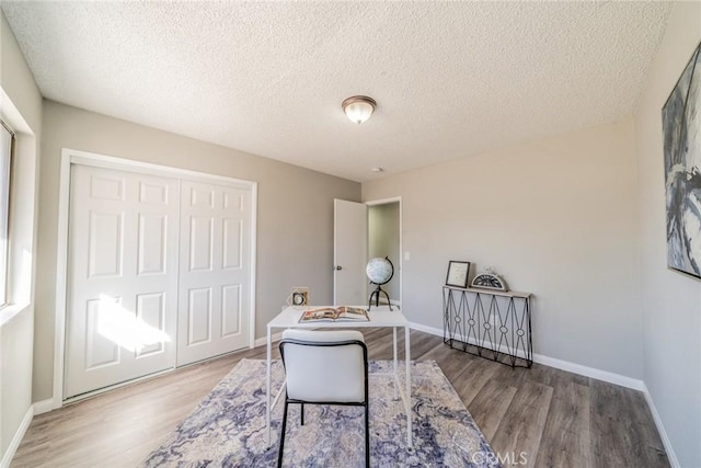 office with a textured ceiling, baseboards, and wood finished floors