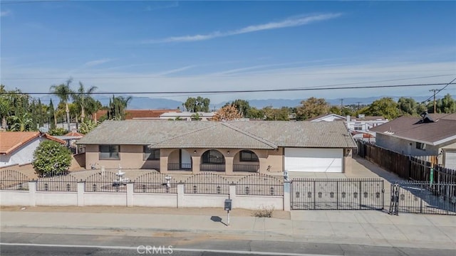 single story home with a fenced front yard, concrete driveway, a garage, and stucco siding