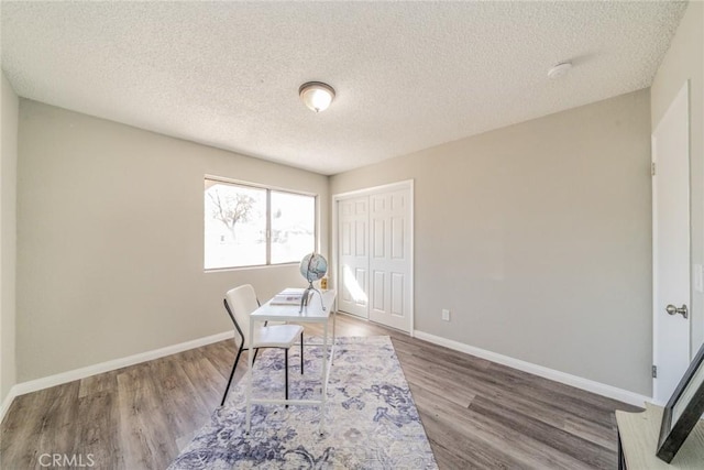 office area featuring a textured ceiling, wood finished floors, and baseboards