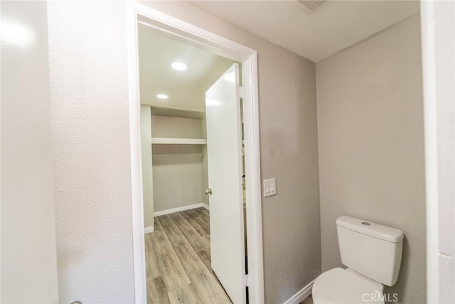 bathroom featuring recessed lighting, wood finished floors, toilet, and baseboards