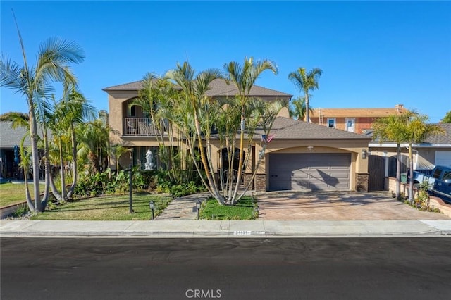 view of front of property with driveway, a front yard, a garage, and stucco siding