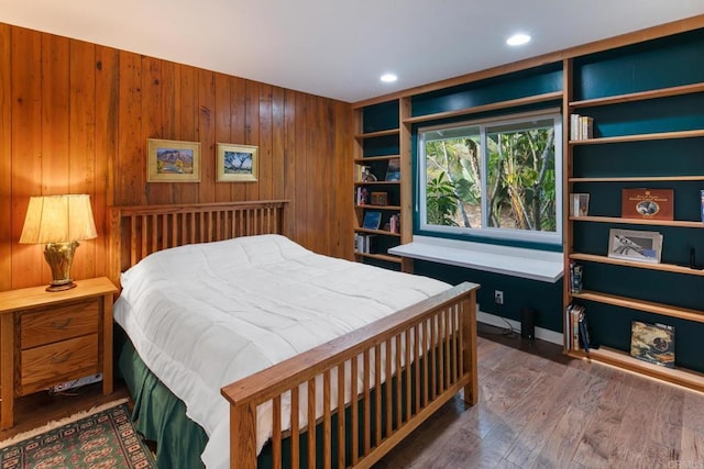 bedroom featuring wood walls, wood finished floors, and recessed lighting