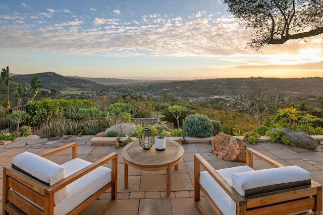 patio terrace at dusk featuring an outdoor hangout area and a mountain view