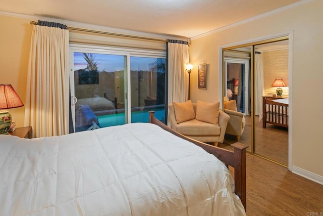 bedroom featuring wood finished floors, baseboards, access to exterior, ornamental molding, and a closet