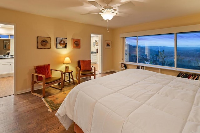 bedroom featuring a ceiling fan, baseboards, and wood finished floors