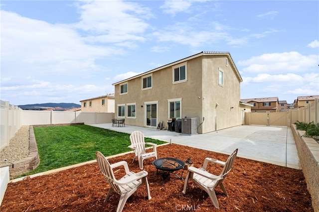 back of property featuring an outdoor fire pit, a patio, a gate, central AC, and stucco siding