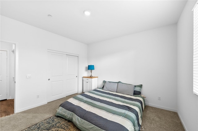 bedroom featuring carpet, a closet, and baseboards