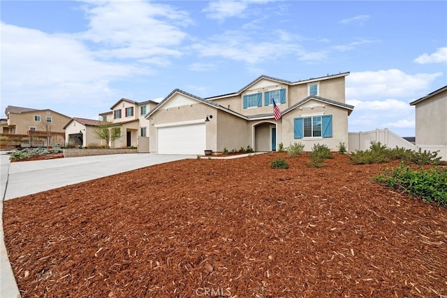 traditional-style home featuring a garage, concrete driveway, fence, and stucco siding