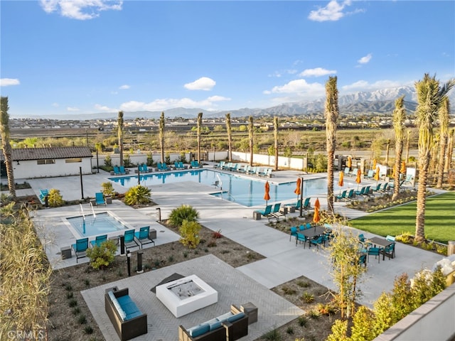 surrounding community featuring a patio area, an outdoor fire pit, a mountain view, and a pool