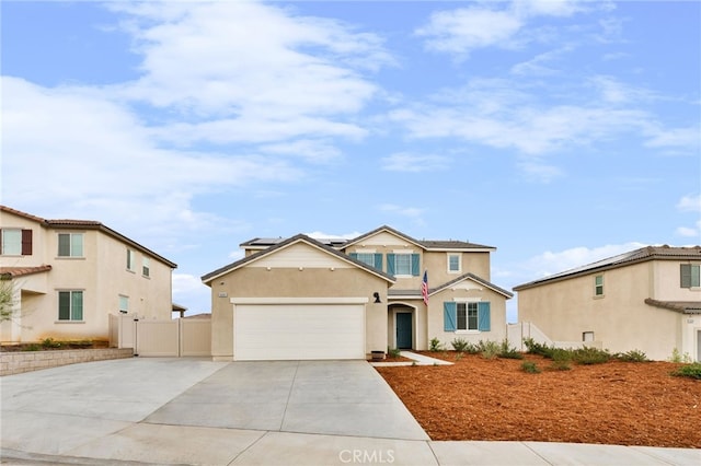 view of front facade with solar panels, concrete driveway, an attached garage, fence, and stucco siding