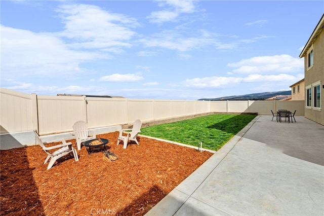 view of yard with an outdoor fire pit, a fenced backyard, and a patio