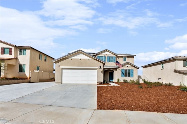 view of front of house with solar panels, stucco siding, fence, a garage, and driveway