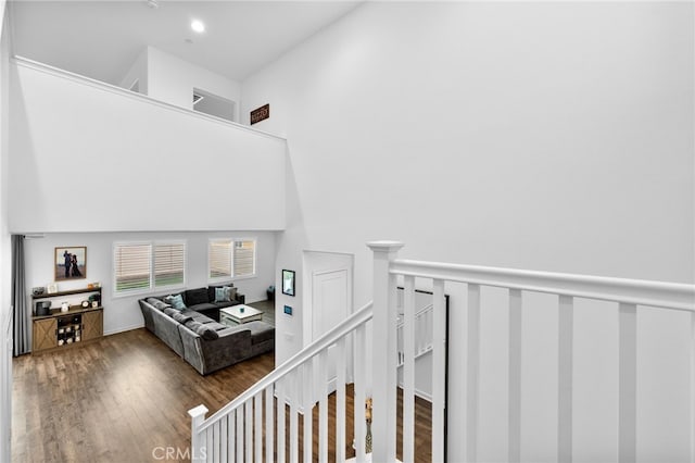 staircase featuring a high ceiling and wood finished floors