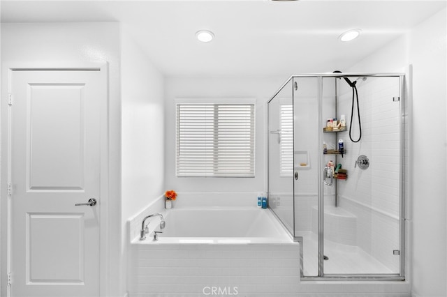 bathroom featuring a garden tub, a shower stall, and recessed lighting