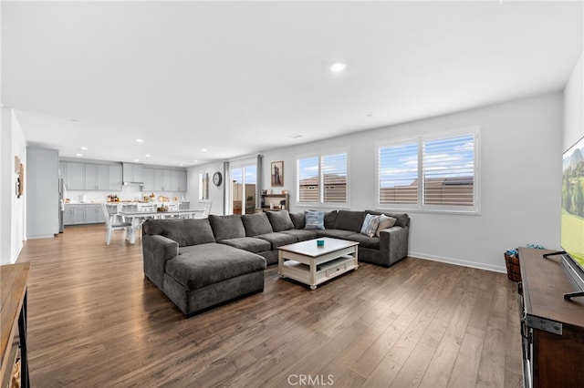 living room with baseboards, wood finished floors, and recessed lighting