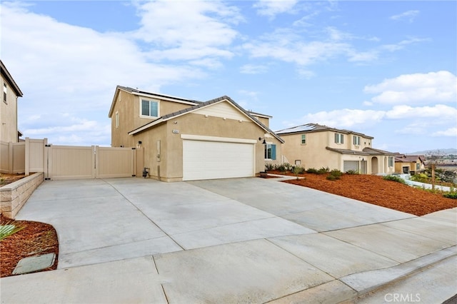 view of front facade featuring a garage, fence, concrete driveway, a gate, and stucco siding