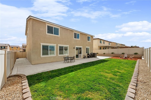 back of house featuring a lawn, a patio area, a fenced backyard, and stucco siding