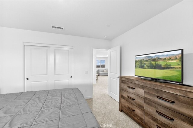 bedroom featuring light colored carpet, a closet, and visible vents