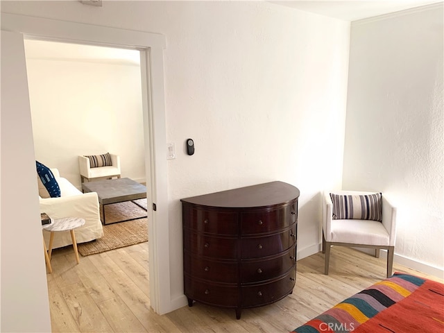 living area with baseboards and wood finished floors