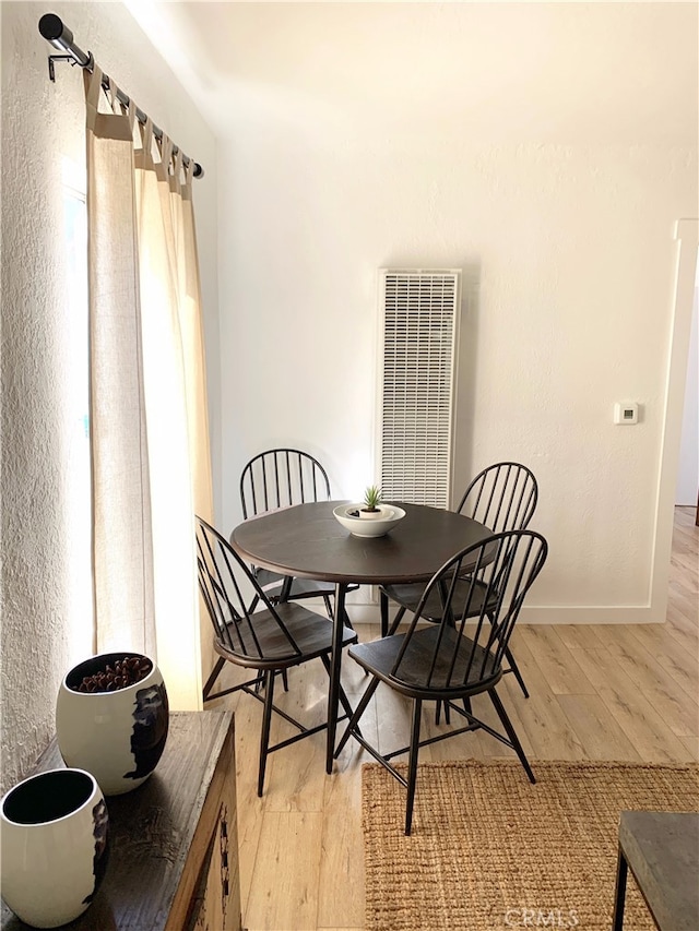 dining room with visible vents, light wood-style flooring, and baseboards