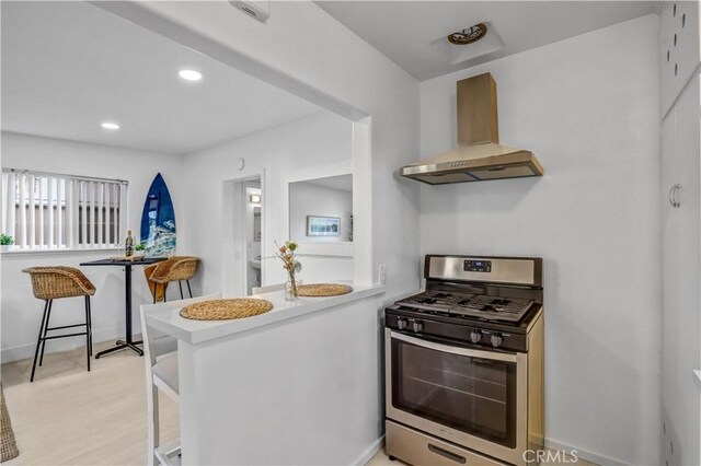 309 W Avenida Palizada, San Clemente, CA 92672 - kitchen with recessed lighting, a peninsula, stainless steel gas range, light wood-type flooring, and wall chimney exhaust hood