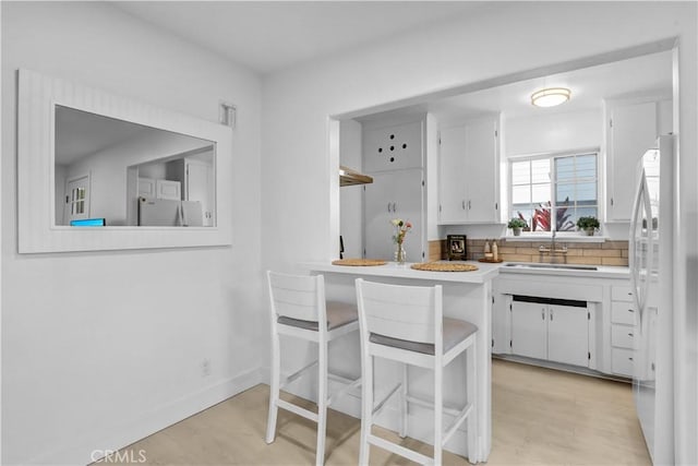 309 W Avenida Palizada, San Clemente, CA 92672 - kitchen with baseboards, light countertops, freestanding refrigerator, and white cabinetry