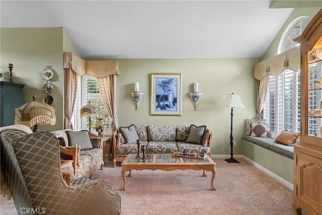 carpeted living room featuring baseboards and vaulted ceiling