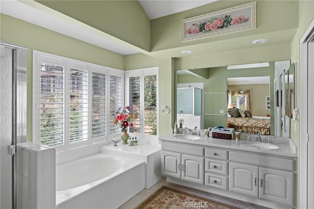 full bathroom with tile patterned flooring, double vanity, a sink, and a bath