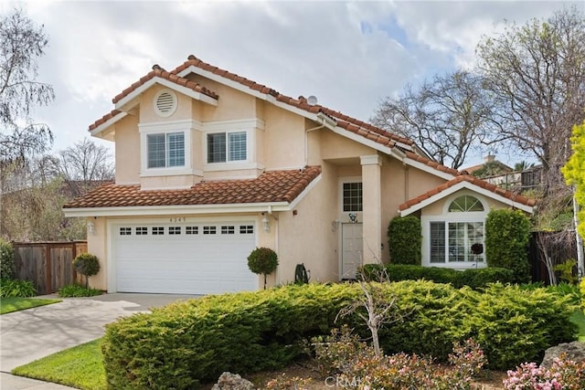 mediterranean / spanish house featuring stucco siding, fence, a garage, driveway, and a tiled roof