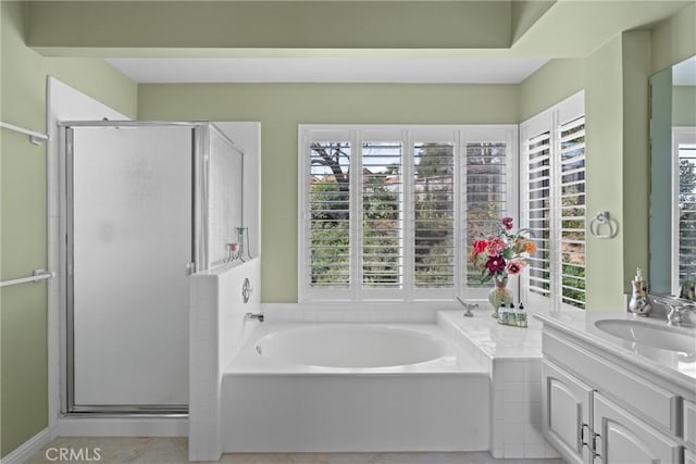 bathroom with a stall shower, a garden tub, and a healthy amount of sunlight