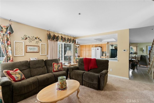 living area with light carpet and baseboards