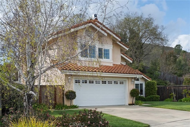 view of front of house with a chimney, fence, concrete driveway, and stucco siding