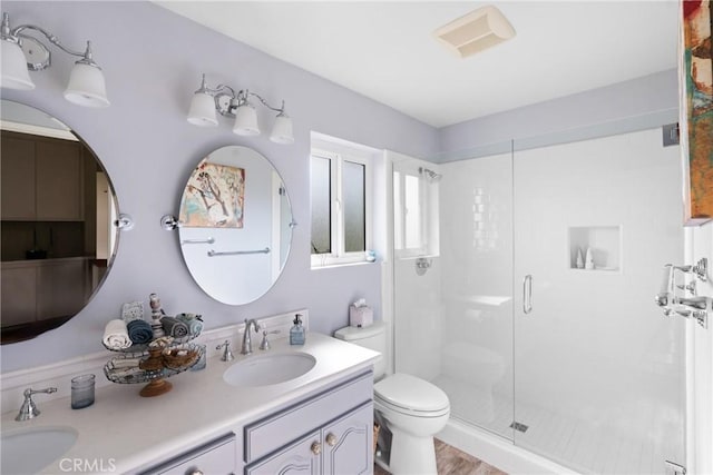 bathroom featuring a stall shower, a sink, and toilet