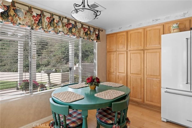 dining space featuring light wood-style floors, visible vents, and a wealth of natural light