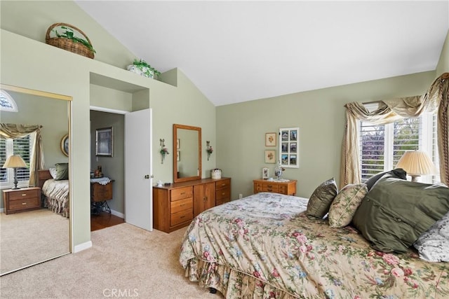 carpeted bedroom featuring high vaulted ceiling and a closet