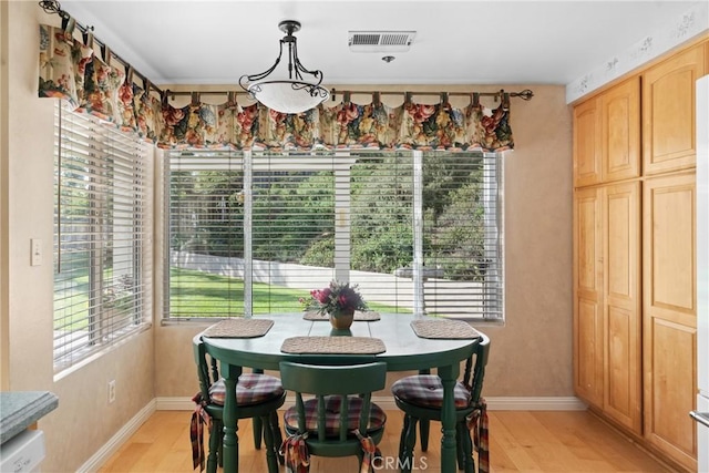 dining room featuring baseboards, visible vents, and light wood-style floors