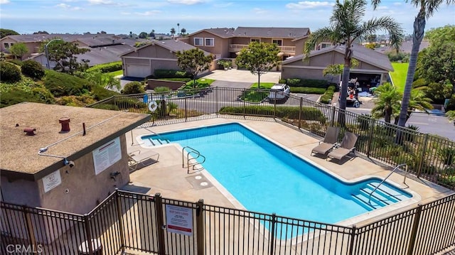 pool with a residential view, a patio, and fence